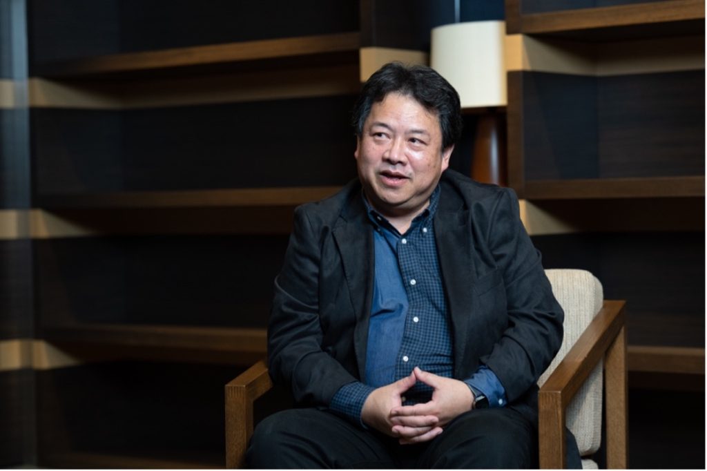 椅子に座る男性 中程度の精度で自動的に生成された説明